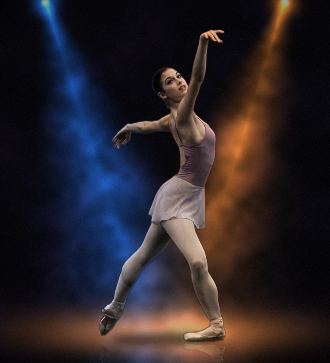 Carola Sicheri, ballerina di danza classica in posa sul palcoscenico nero con riflettori blu e arancio