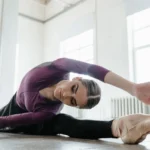 Check-up online: a cosa serve e come funziona Ballerina in viola si allunga in spaccata con scarpette a punta in sala luminosa